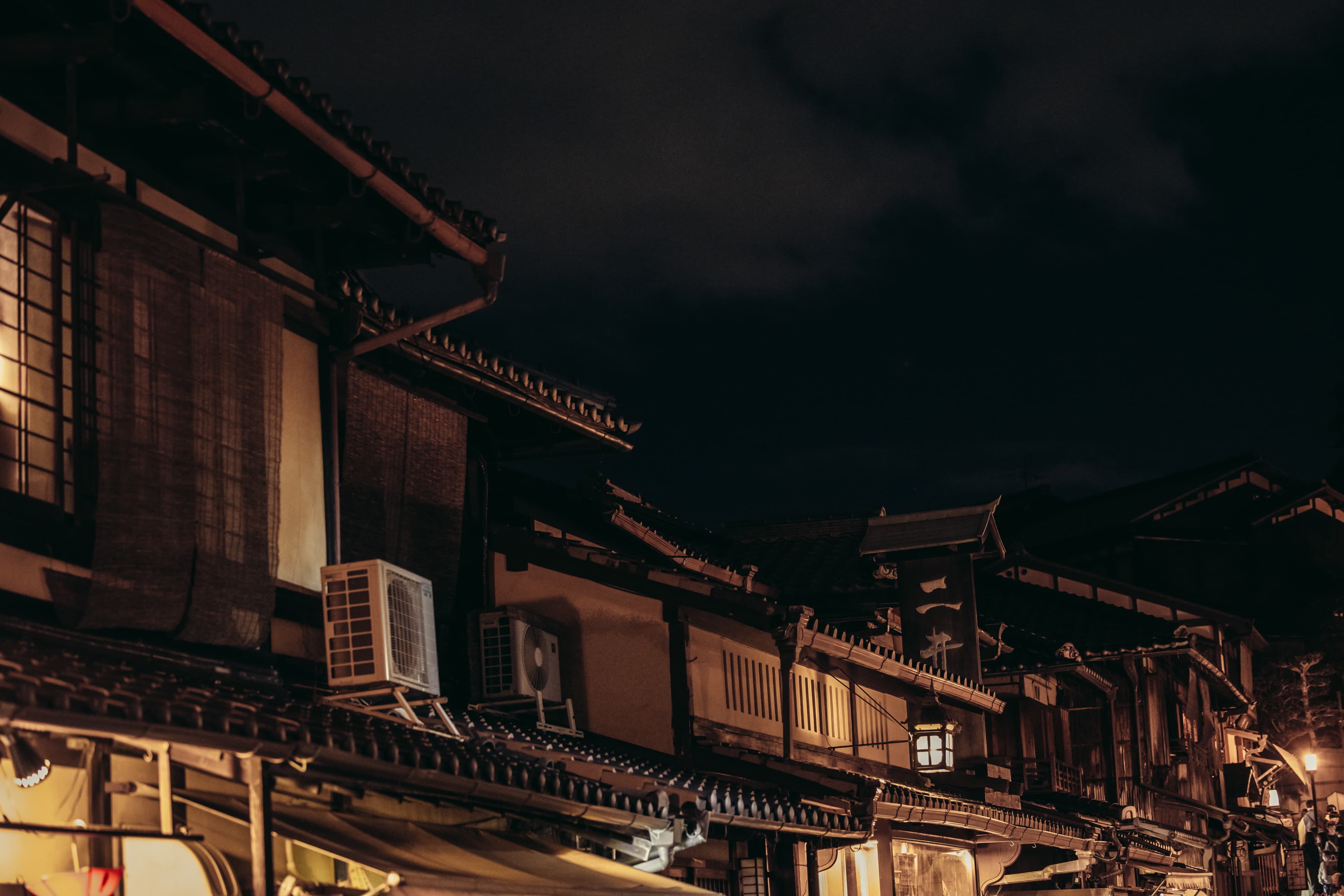Traditional machiya buildings in Gion, Kyoto at night under warm lantern light